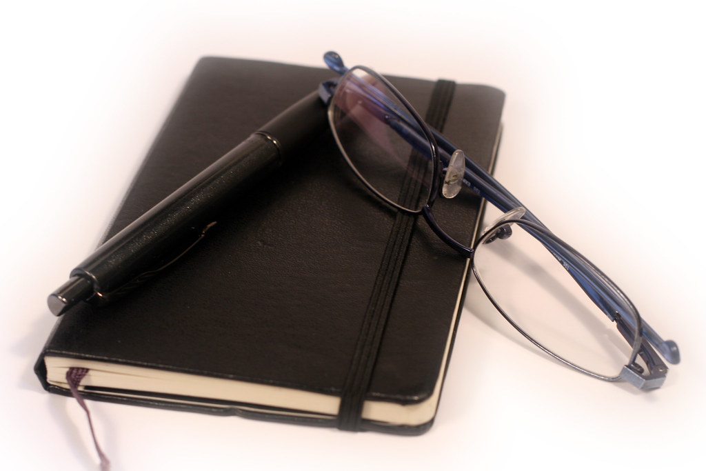 A notebook and a pair of reading glasses