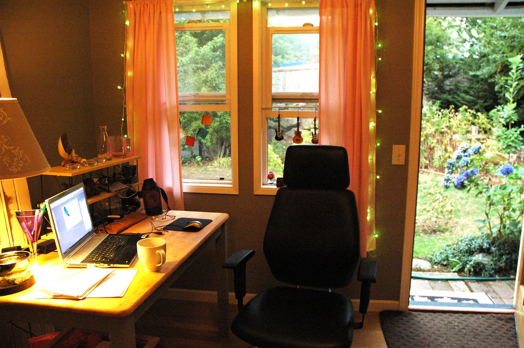 A laptop on a home office desk with string lights
